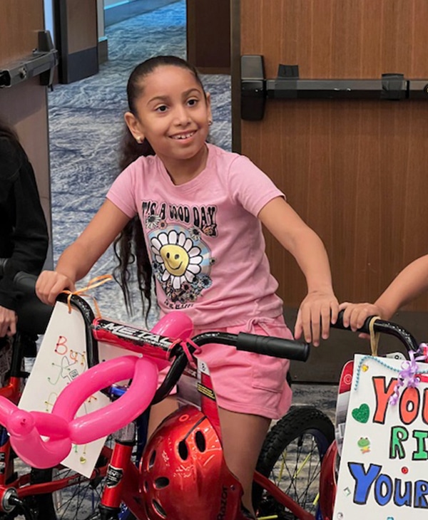 Young girl who is excited to be getting her first bike made during a team building activity