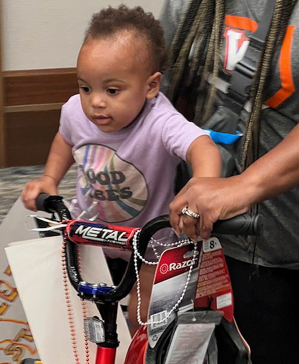 Young child sitting on their bike that was donated to them