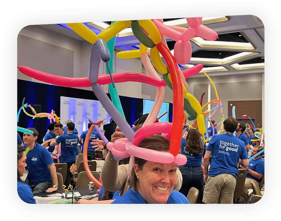 Woman wearing a balloon hat, created as en event activity in our wheels for the world team building program